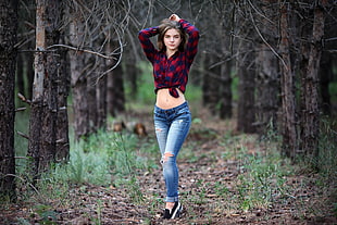 woman wearing blue and red plaid top and distressed blue denim jeans