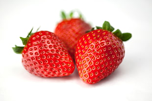 macro photography of three strawberries
