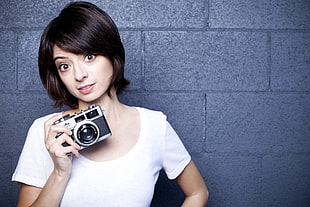 woman holding silver and black DSLR camera