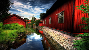 landscape photography of red houses near trees and body of water