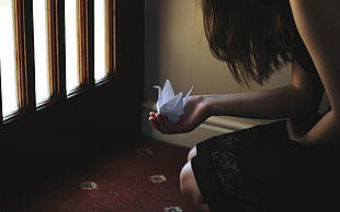 woman wearing black dress holding white origami paper HD wallpaper