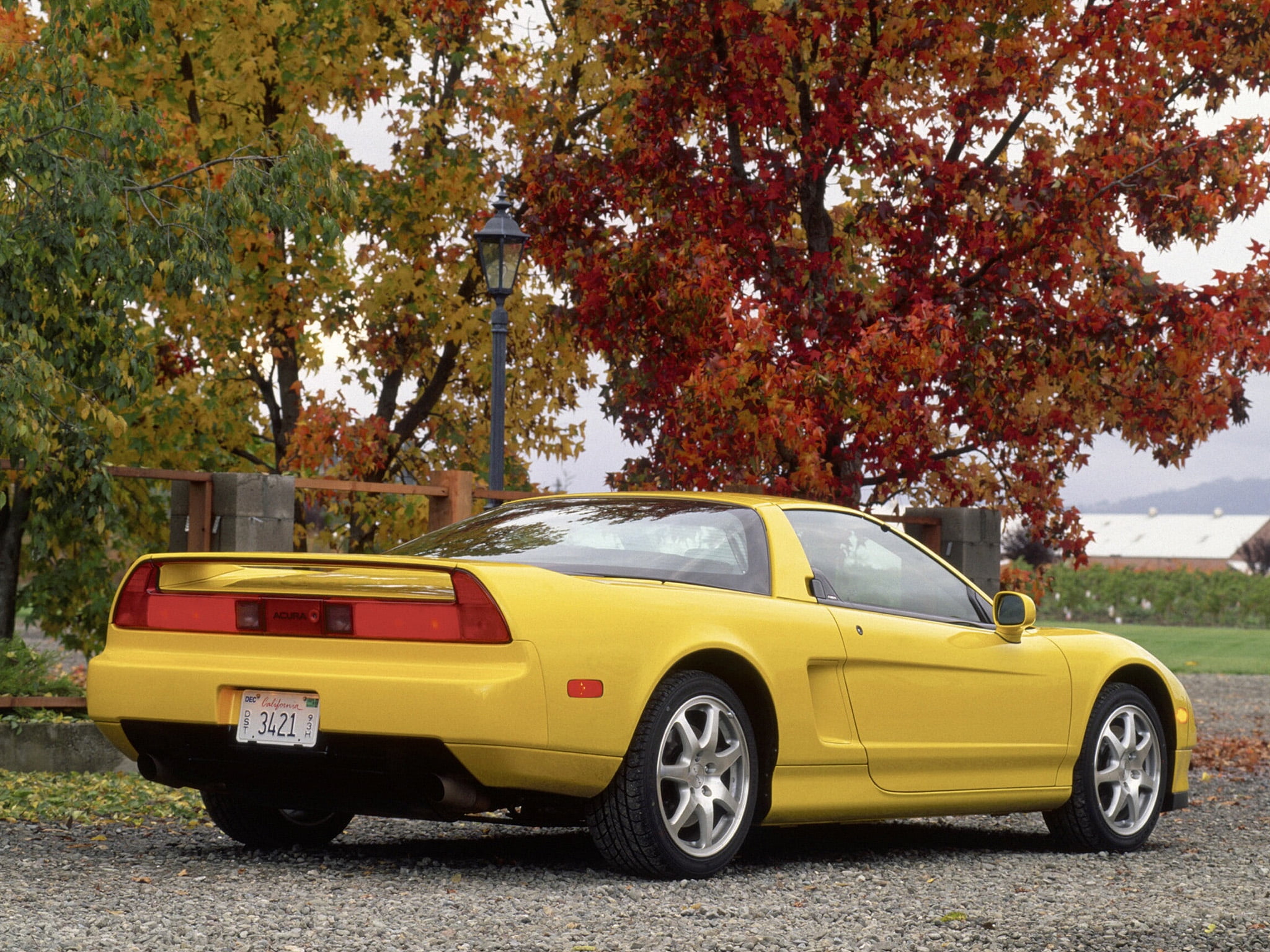 yellow Chevrolet Corvette C5 parked on grey gravel