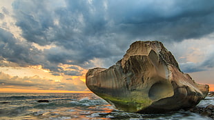 landscape photography of rock formation on body of water during golden hour, fangshan