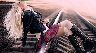 woman wearing red mini skirt sitting on rail way