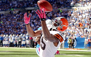 football player catching brown football