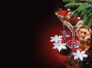 still life photography of two clear martini glasses beside Christmas tree
