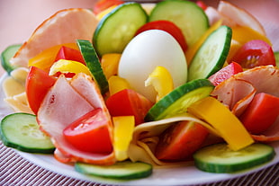 close up photography of slice cucumbers, tomatoes, and egg in plate
