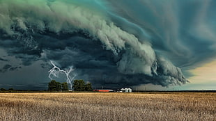 rain cloud with lightning over brown fields