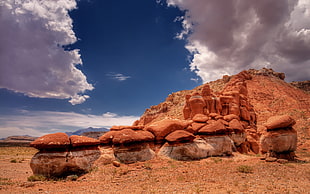 brown rock formation under gray and blue cloudy sky during daytime HD wallpaper