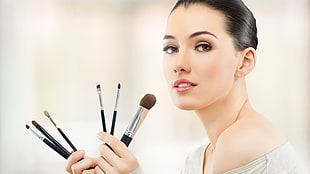 woman holding black make-up brushes HD wallpaper