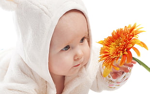 baby' holding orange flowers
