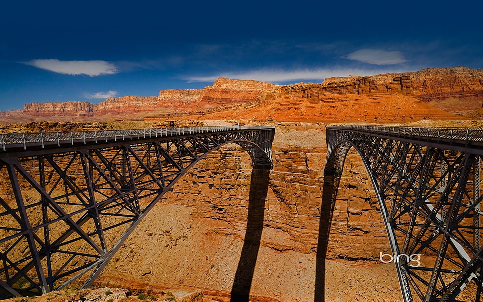 two black steel bridges on brown rock formation HD wallpaper