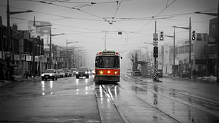 red and black city tram, cityscape, tram, selective coloring, rain