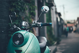 tilt-shift photo of green motorcycle