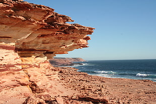 brown rock formation near at body of water during daytime, kalbarri