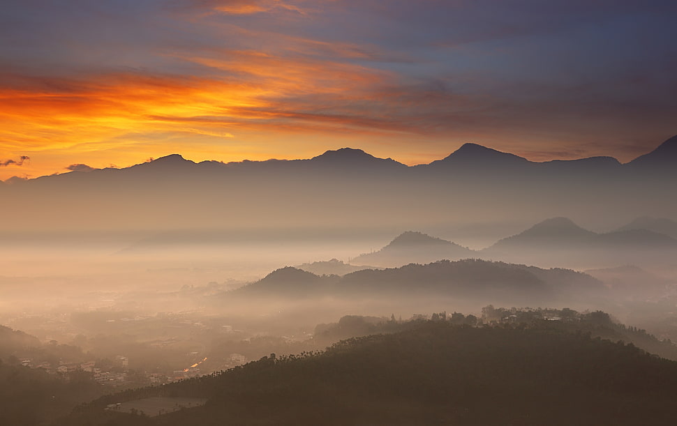 photo of brown rocky mountains covered with fog during golden hour HD wallpaper