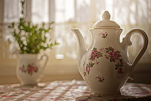 closeup photo of white and pink floral teapot