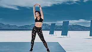 woman wearing black sports bra flexing her arms near solar panels HD wallpaper