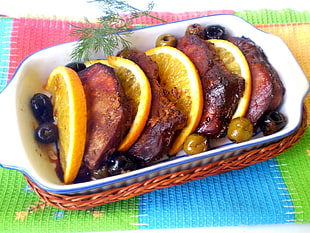 food photography of roasted meats with sliced oranges