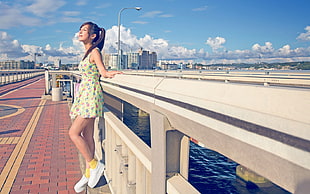 girl standing on brown concrete brick ground near buildings under white and blue sky during daytime
