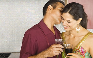 man kissed the cheek of the woman while holding turkish tea glass filled with black liquid HD wallpaper