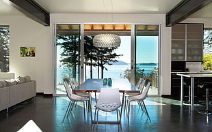 dining set with clear glass door and body of water in background