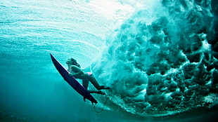 surfer diving underwater to avoid ocean waves