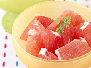 closeup photo of sliced pomelo on yellow bowl HD wallpaper
