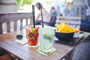 shallow focus photography of two clear glass containing a juice