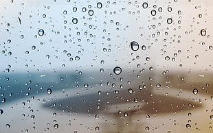 close up photography of raindrops on vehicle windshield