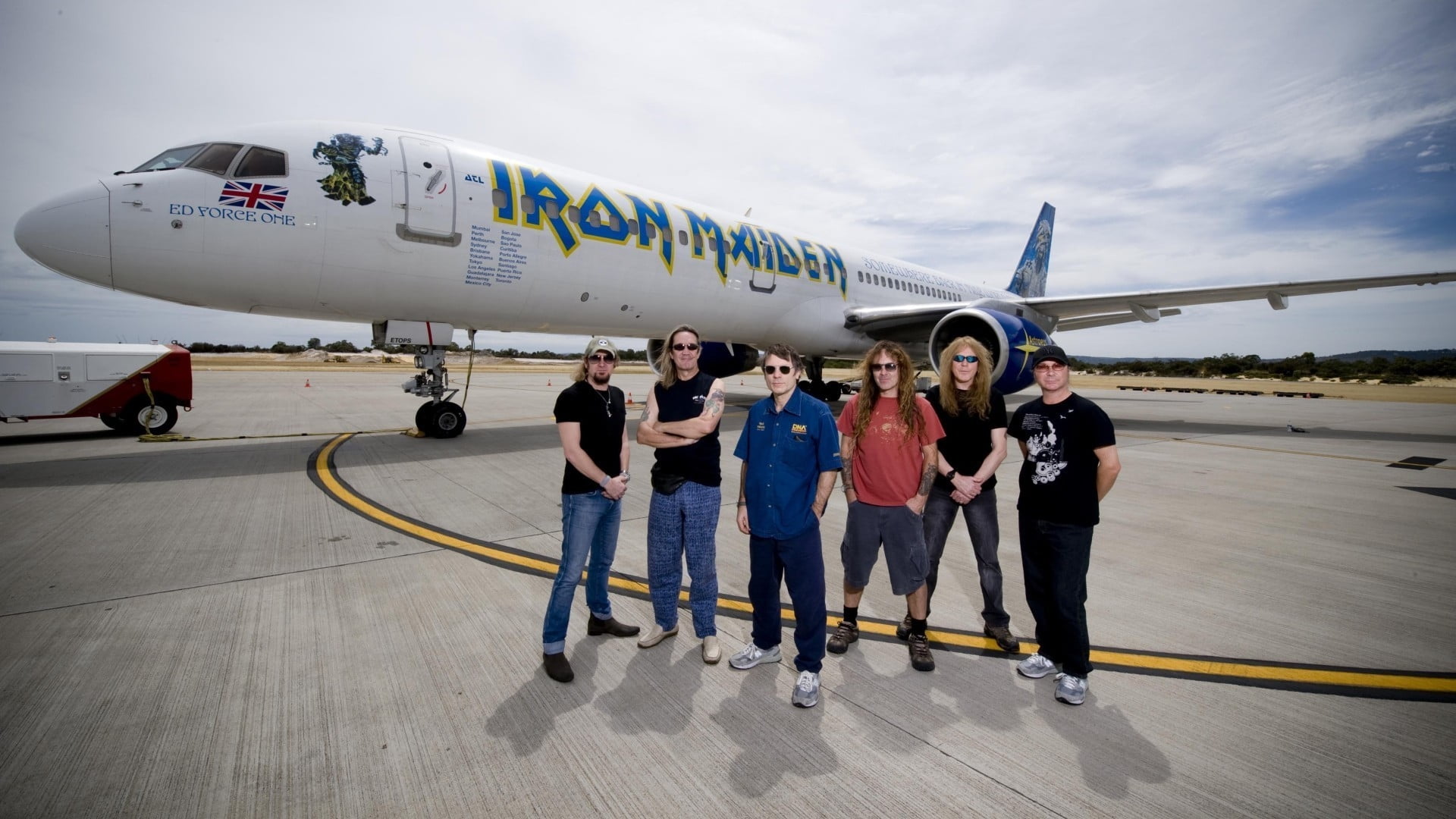 six man standing back of white airplane