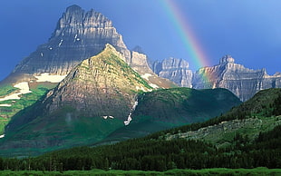 mountain beside rainbow during daytime