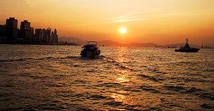 boat in sea under orange sky, hong kong