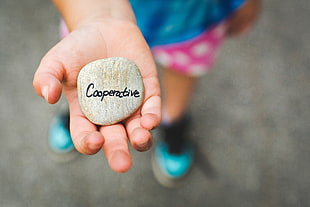 child holding gray cooperative printed stone HD wallpaper