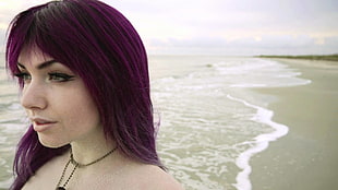 purpled haired woman standing on seashore