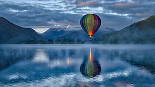 hot air balloon above of body of water photography HD wallpaper