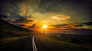 asphalt road beside mountain during sunset