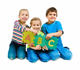three toddler's holding green and white puzzle mat