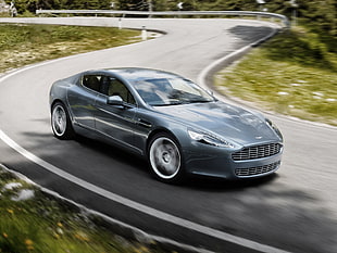time lapse photography of Aston Martin coupe hitting road during daytime