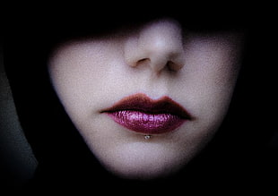 person's purple lips and silver-colored accessory
