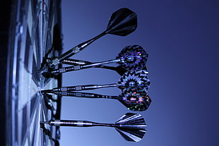 selective photography of dart pins on dartboard