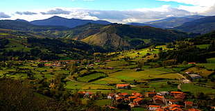 houses near green grass-filled Mountains, cantabria