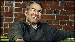 man wearing black jacket while smiling HD wallpaper
