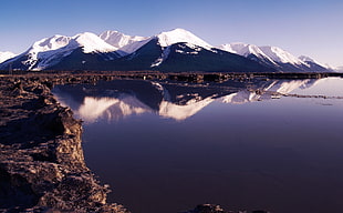 photo of snow mountain near body of water