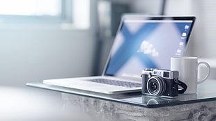 MacBook Pro beside white ceramic mug and MILC camera HD wallpaper