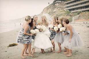 bride together with her bridesmaids on beach at daytime