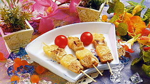 barbeque skewers in white ceramic tray garnish with two cherry tomatoes