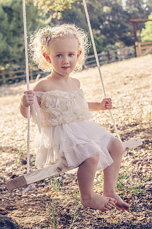 girl with dress sitting on swing
