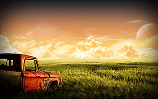 red pickup truck on grass field under sunset sky