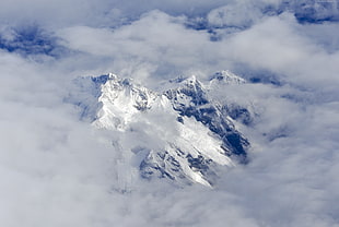 snow-covered mountain with white clouds